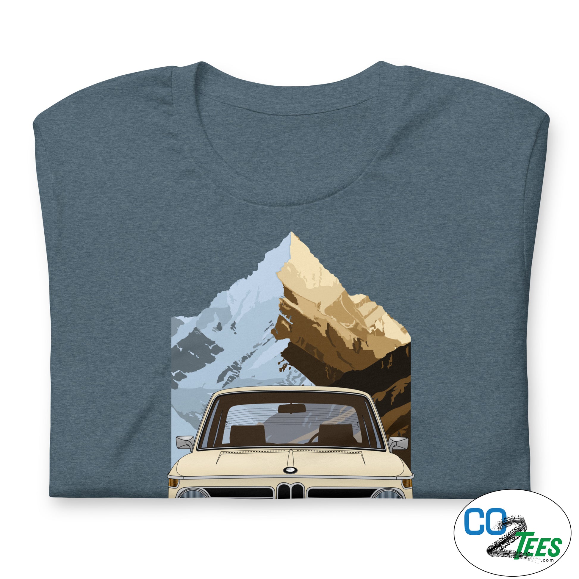 Folded blue t-shirt with a graphic of a car and mountains on a white background